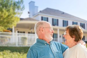 Happy Senior Couple in the Front Yard of Their House.