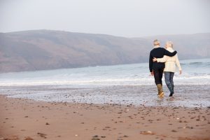 Senior Couple Walking Along Winter Beach